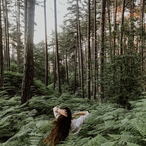 woman among leaves in forest