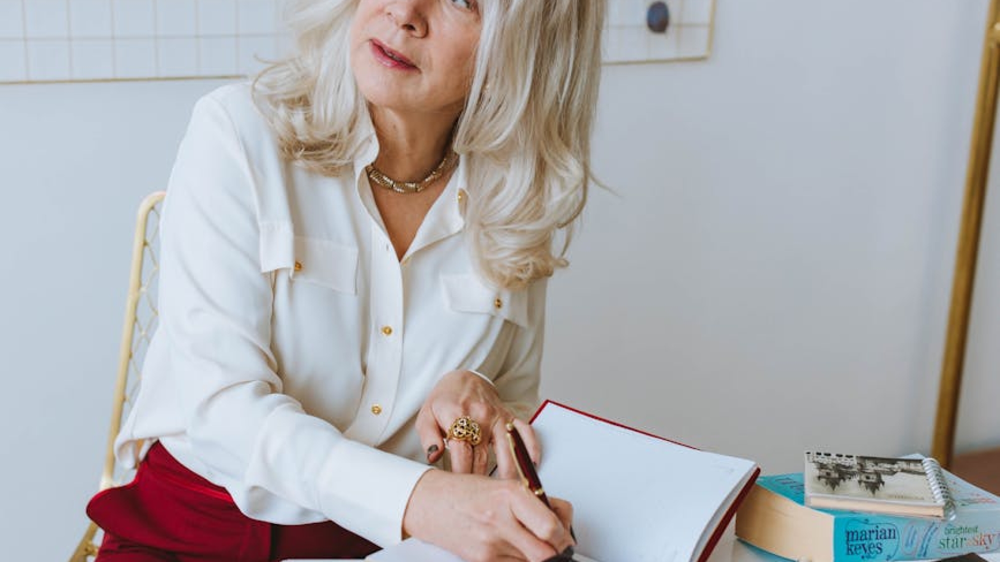 senior business woman looking away while writing on a journal