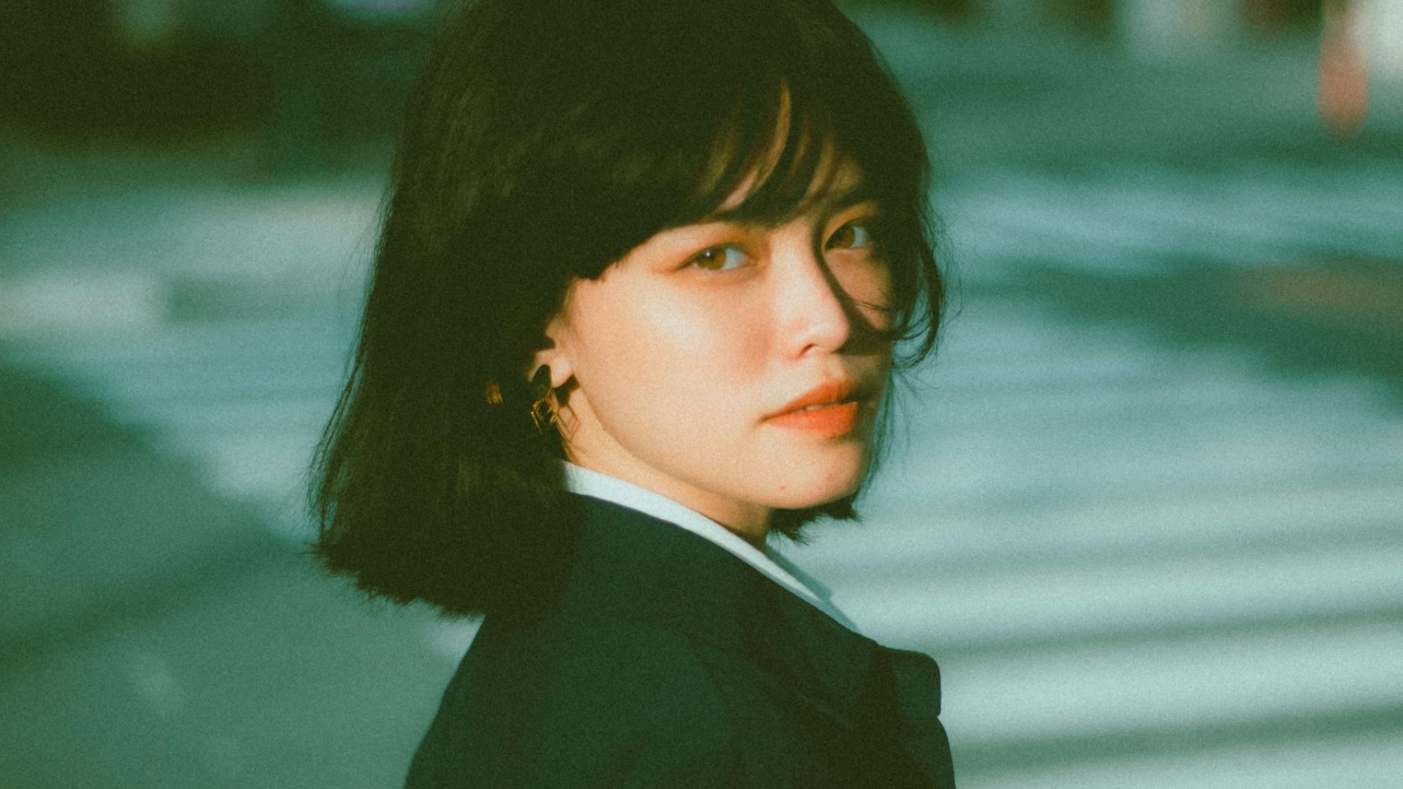 pensive young ethnic businesswoman looking at camera on street
